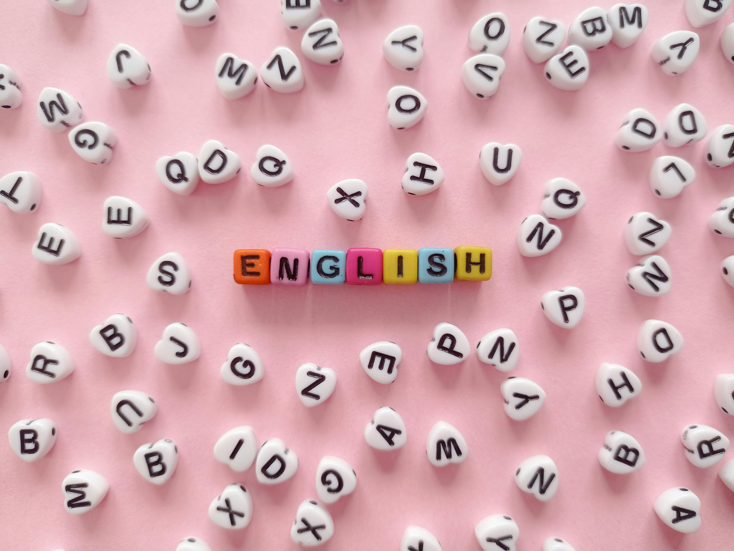 The Word "English" Made of Beads with Letters Lying on Pink Background